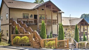 A two-story building with a wooden exterior, a balcony on the upper floor, and a staircase leading to the entrance. - Bryson City Condo w/ Spectacular Views & Amenities (Whittier)