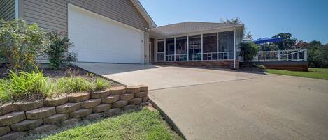 A two-story house with a garage, a covered patio, and a well-maintained lawn.