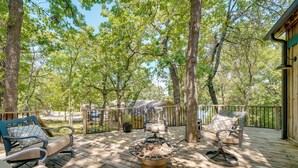 A wooden deck with outdoor furniture, a fire pit, and a view of trees. - Idyllic Eufaula Vacation Rental: Close to Lake! (Eufaula)