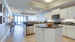 A spacious kitchen with white cabinets, granite countertops, and modern appliances including a microwave and oven. - Dauphin Island Condo in Holiday Isle With Balcony! (Dauphin Island)