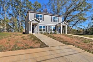 A two-story house with a front porch, a driveway, and a grassy yard. - Greer Getaway w/ Smart TV ~ 1 Mi to Dtwn! (Greer)