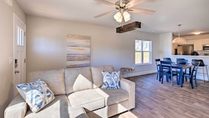 A living room with a sofa, a ceiling fan, and a dining area with chairs and a table. - Greer Getaway w/ Smart TV ~ 1 Mi to Dtwn! (Greer)