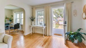 A spacious room with a wooden floor, a white desk, and a dining area with chairs and a table. - Chic Front Royal Retreat Near Shenandoah River! (Front Royal)