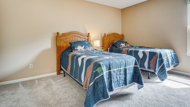 A bedroom with two single beds, a ceiling fan, and a window. - Spacious Lewis Center Home w/ Yard & Gas Grill! (Lewis Center)