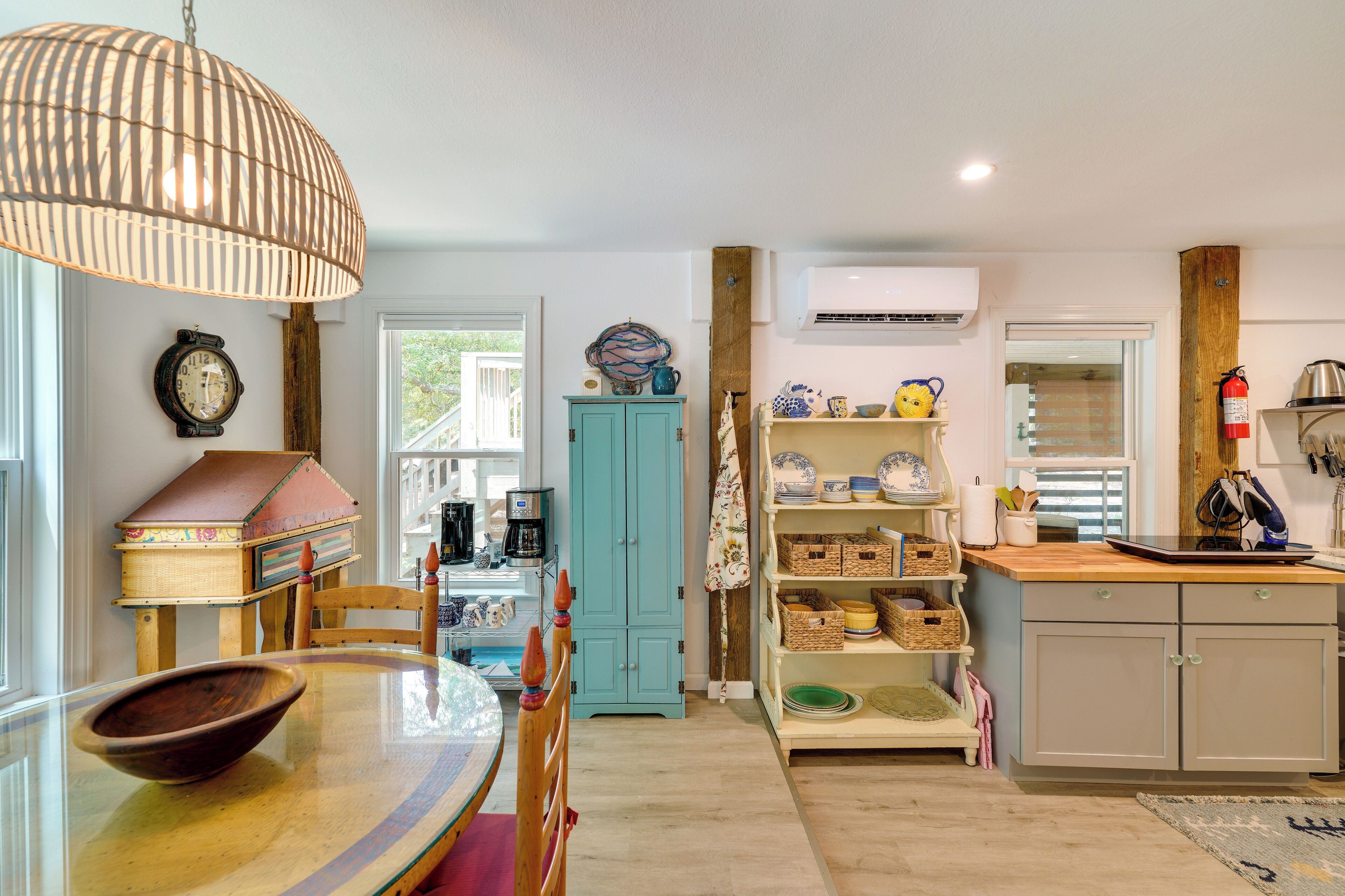 A kitchen with a wooden table, a blue cabinet, and a hanging light fixture.