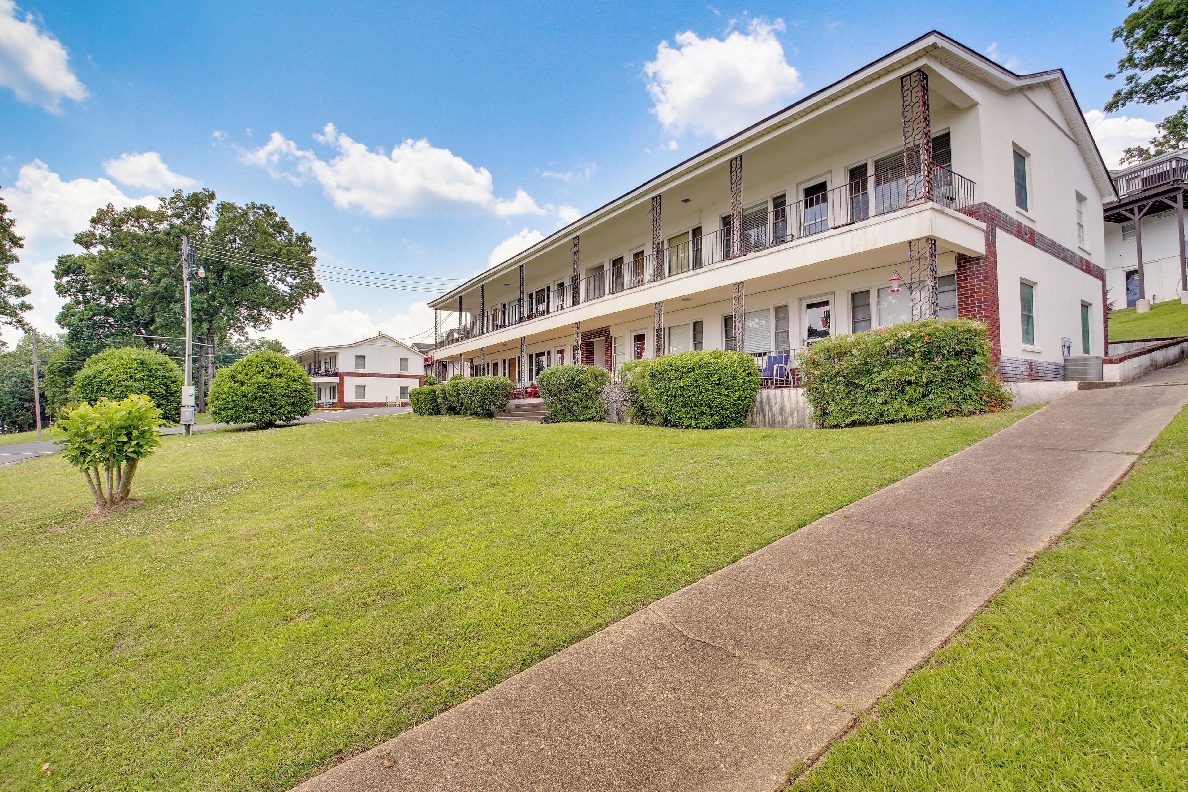 A two-story motel with a central courtyard, a covered walkway, and a well-maintained lawn.
