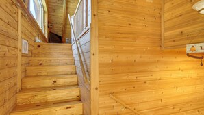 A wooden staircase leading to a second-floor area with a window and a wooden wall. - Waterfront 'UP Badger Lodge Bnb' on Powell Lake (Wetmore)