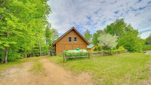A wooden cabin with a dirt path leading to it, surrounded by trees and greenery. - Waterfront 'UP Badger Lodge Bnb' on Powell Lake (Wetmore)