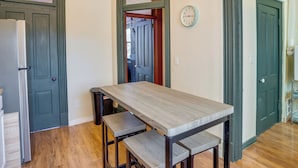A kitchen with a wooden table, two benches, a refrigerator, and a clock on the wall. - Downtown Montrose Apartment, 12 Mi to Natl Park! (Montrose)