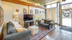 A living room with a sofa, a coffee table, and a television. - Cozy Abode in Historic Yankton - Heart of the City (Yankton)
