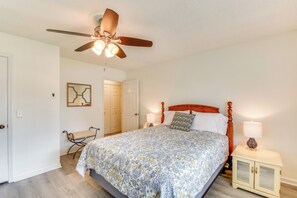 A bedroom with a bed, a ceiling fan, a bedside table with a lamp, and a bench by the door. - Charming Seneca Home - 3 Mi to Memorial Stadium! (Seneca)
