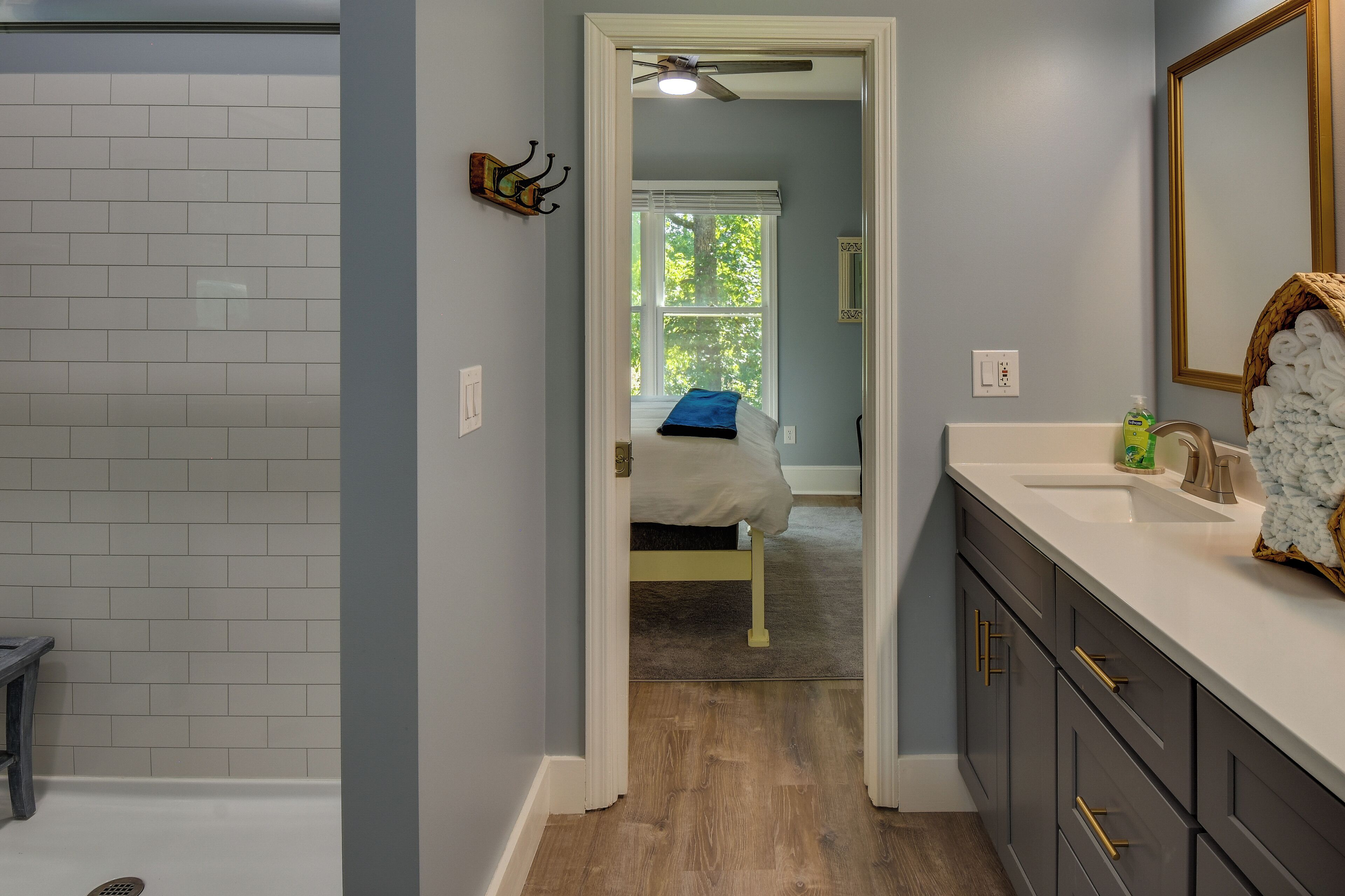 A bathroom with a white sink, dark cabinets, and a mirror.