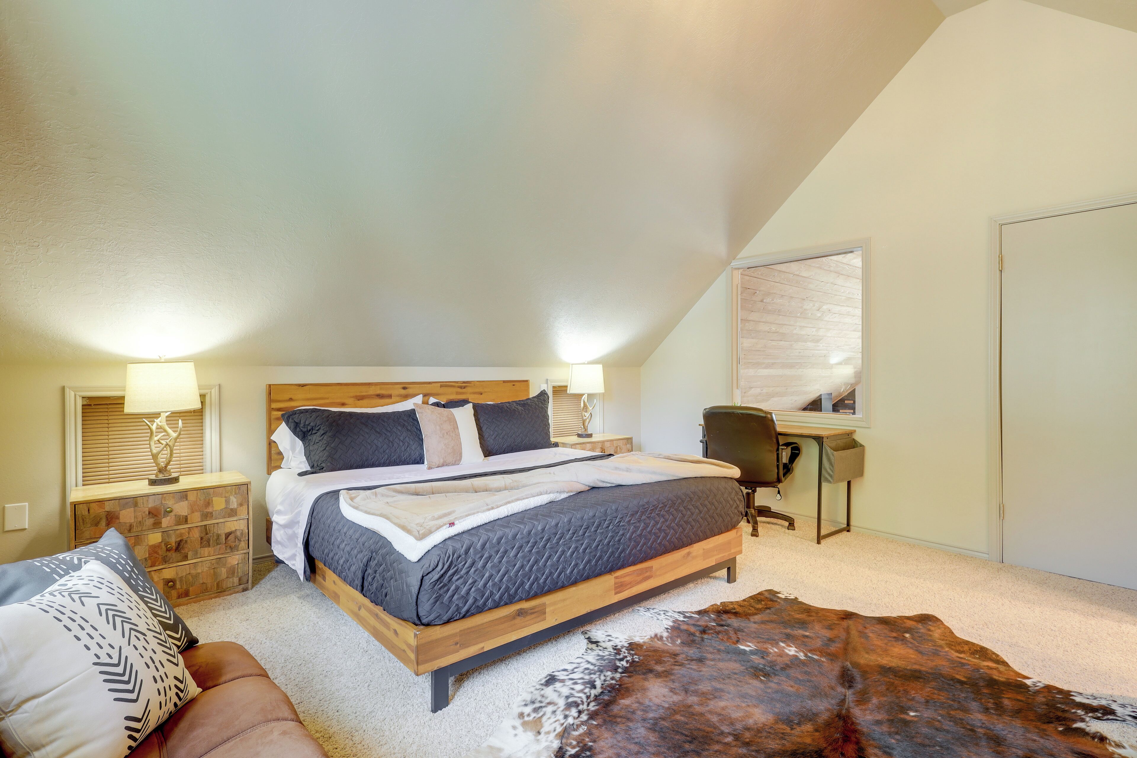 A bedroom with a bed, a desk, and a chair.