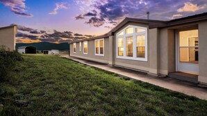 A row of single-story houses with large windows and a grassy yard. - Angel Fire Home: Sangre de Cristo Mountains View! (Angel Fire)