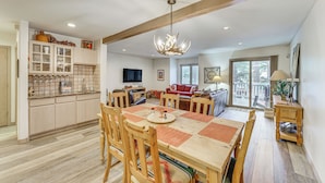 A spacious living area with a large wooden dining table, comfortable seating, and a television. - Half Mi to Angel Fire Resort: Townhome w/ Grill! (Angel Fire)