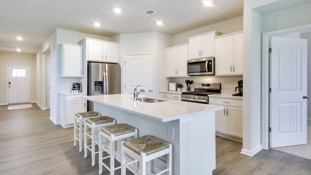 A modern kitchen with white cabinetry, a stainless steel refrigerator, a built-in microwave, and a large island with bar stools. - 3 Mi to Bethany Beach: Ocean View Home w/ Patio (Ocean View)