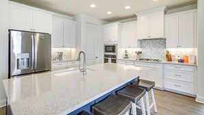 A modern kitchen with white cabinets, stainless steel appliances, and a granite countertop. - Ocean View Home w/ Kayaks ~ 2 Mi to Bethany Beach (Ocean View)