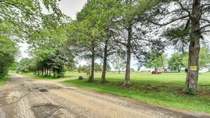 Een landweg omzoomd door bomen, met een bord dat ‘Geen toegang’ aangeeft.