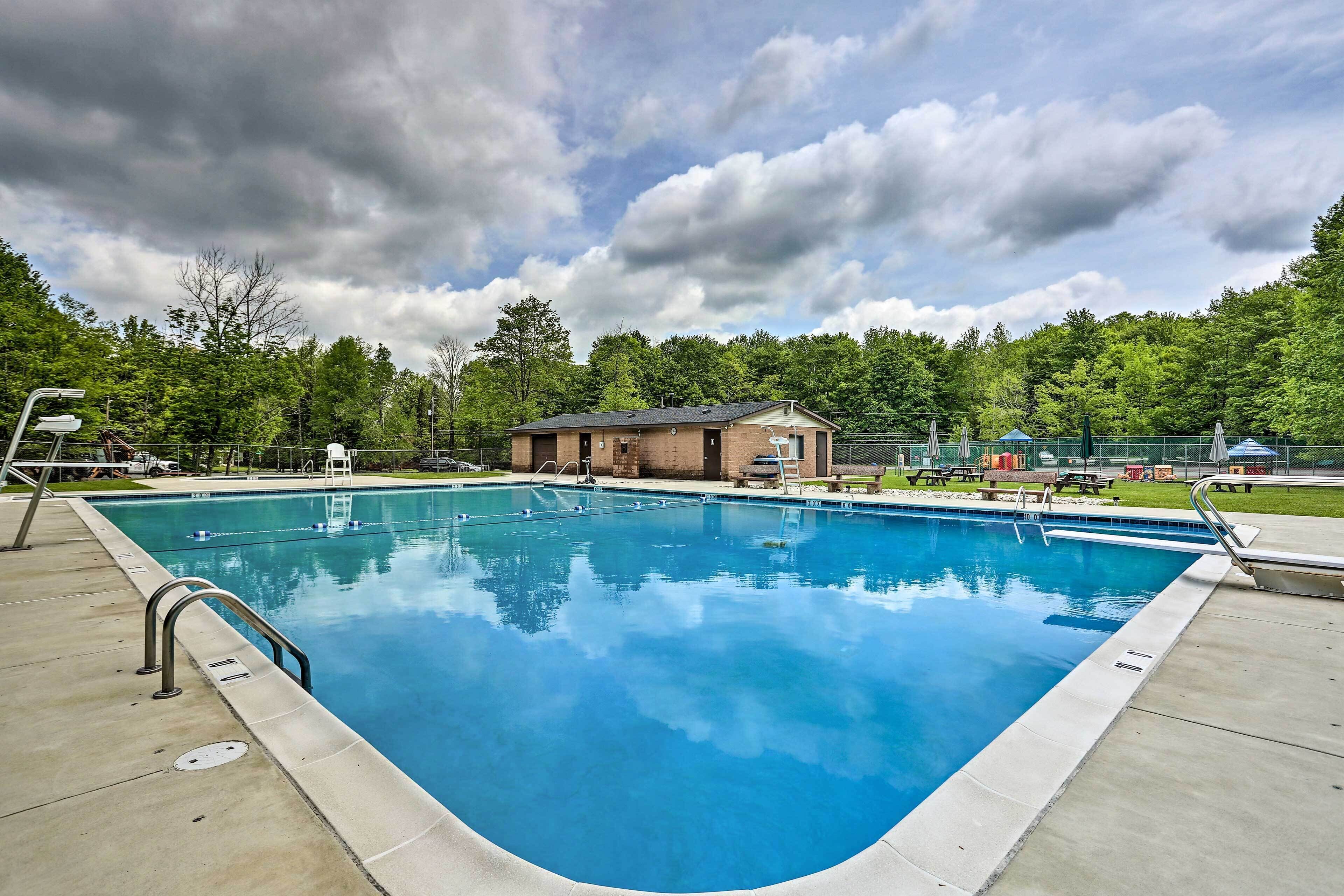 A rectangular swimming pool with a metal handrail on one side, surrounded by a concrete deck.
