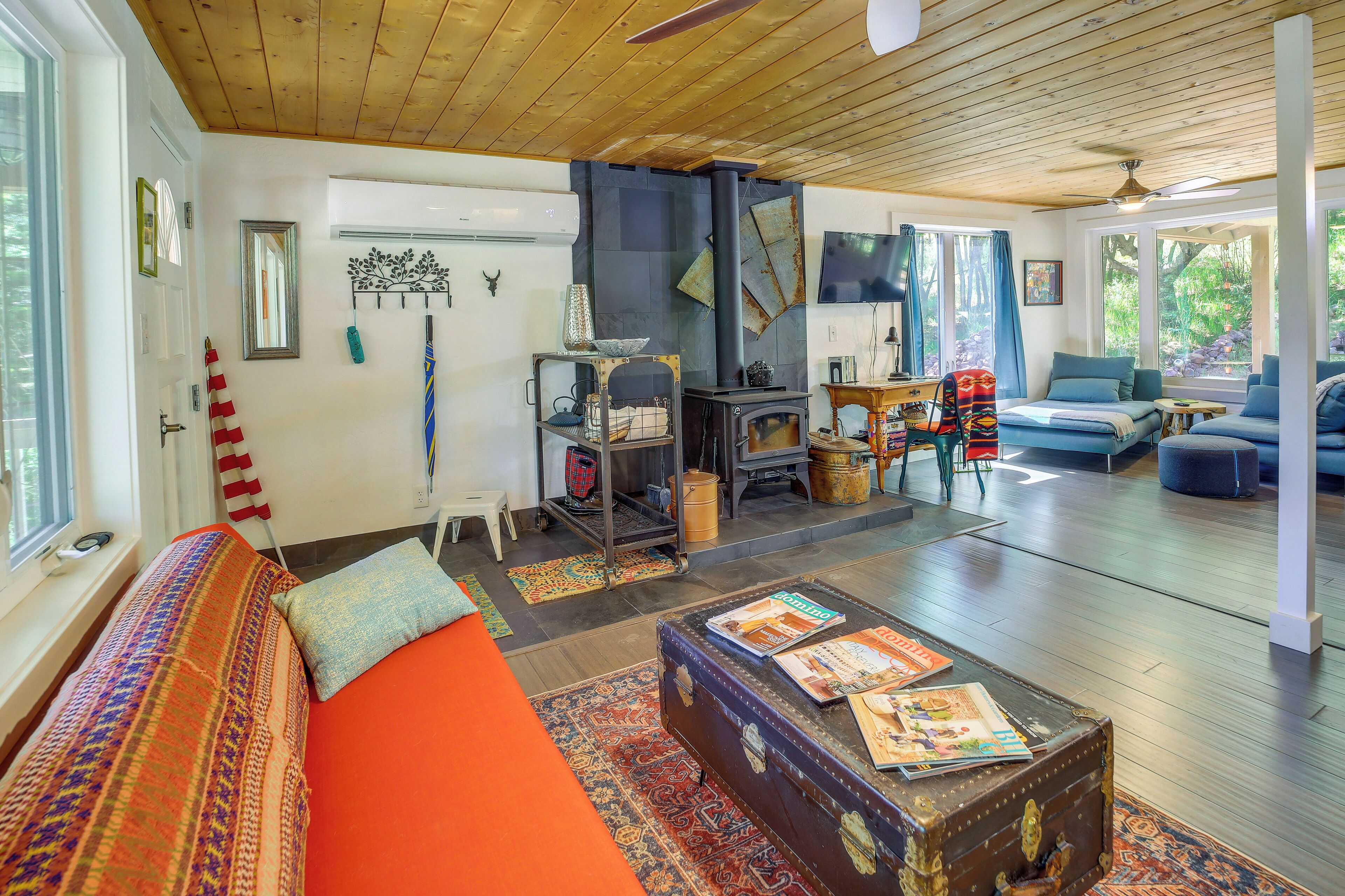 Ein gemütliches Wohnzimmer mit Holzboden, Kamin, Sofa und Couchtisch mit Zeitschriften.