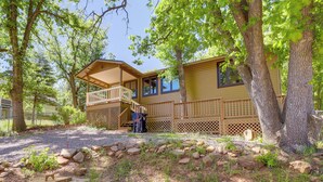 A two-story wooden cabin with a balcony, surrounded by trees and a landscaped garden. - Strawberry Cabin Rental w/ Deck & Mountain Views! (Pine)