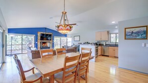 A spacious kitchen with a dining area, large windows, and a fireplace.