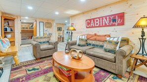 A cozy cabin-style room with two sofas, a coffee table, and a bookshelf. A 'CABIN' sign is prominently displayed on the wall. - Secluded Murphy Vacation Rental w/ Private Hot Tub (Murphy)