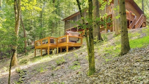 A wooden cabin with a deck and stairs, surrounded by trees and forest. - Secluded Murphy Vacation Rental w/ Private Hot Tub (Murphy)