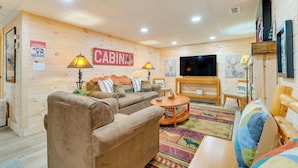 A cozy cabin-style room with a sofa, armchairs, a coffee table, and a TV. - Secluded Murphy Vacation Rental w/ Private Hot Tub (Murphy)