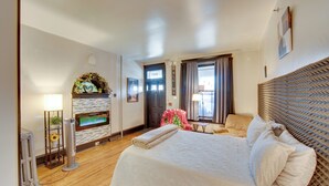 A hotel room with a bed, a TV, a fireplace, a door, and a window. - < 2 Mi to Downtown & Capitol: Harrisburg Hideaway (Harrisburg)