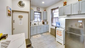 A kitchen with grey cabinets, a stainless steel refrigerator, a stove, and a sink. - < 2 Mi to Downtown & Capitol: Harrisburg Hideaway (Harrisburg)