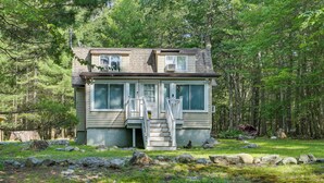 A cabin with a front porch, a staircase, and a large window. - Huguenot Retreat w/ Screened Porch & Lake Access! (Huguenot)