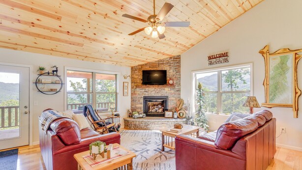 A cozy living room with a fireplace, leather sofas, and a wooden ceiling. - North Carolina Cabin - Pool Table & Mountain Views (Murphy)