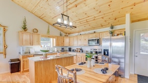 A spacious kitchen with wooden cabinets, a central island, and a stainless steel refrigerator. - North Carolina Cabin - Pool Table & Mountain Views (Murphy)
