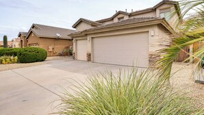 A residential house with a garage, a driveway, and a well-maintained lawn with various plants. - Maricopa Oasis w/ Game Room + Community Perks! (Maricopa)