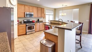 A modern kitchen with wooden cabinets, stainless steel appliances, and a granite countertop. - Maricopa Oasis w/ Game Room + Community Perks! (Maricopa)