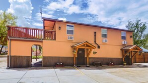 A two-story building with a balcony, a front entrance with a wooden door, and a small porch area. - Southern Colorado Rental: 10 Mi to Mesa Verde (Cortez)