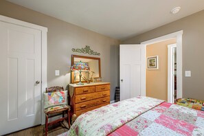 A bedroom with a bed, dresser, chair, and a door leading to another room. - Pet-friendly Retreat w/ Mtn Views in Sylva! (Sylva)
