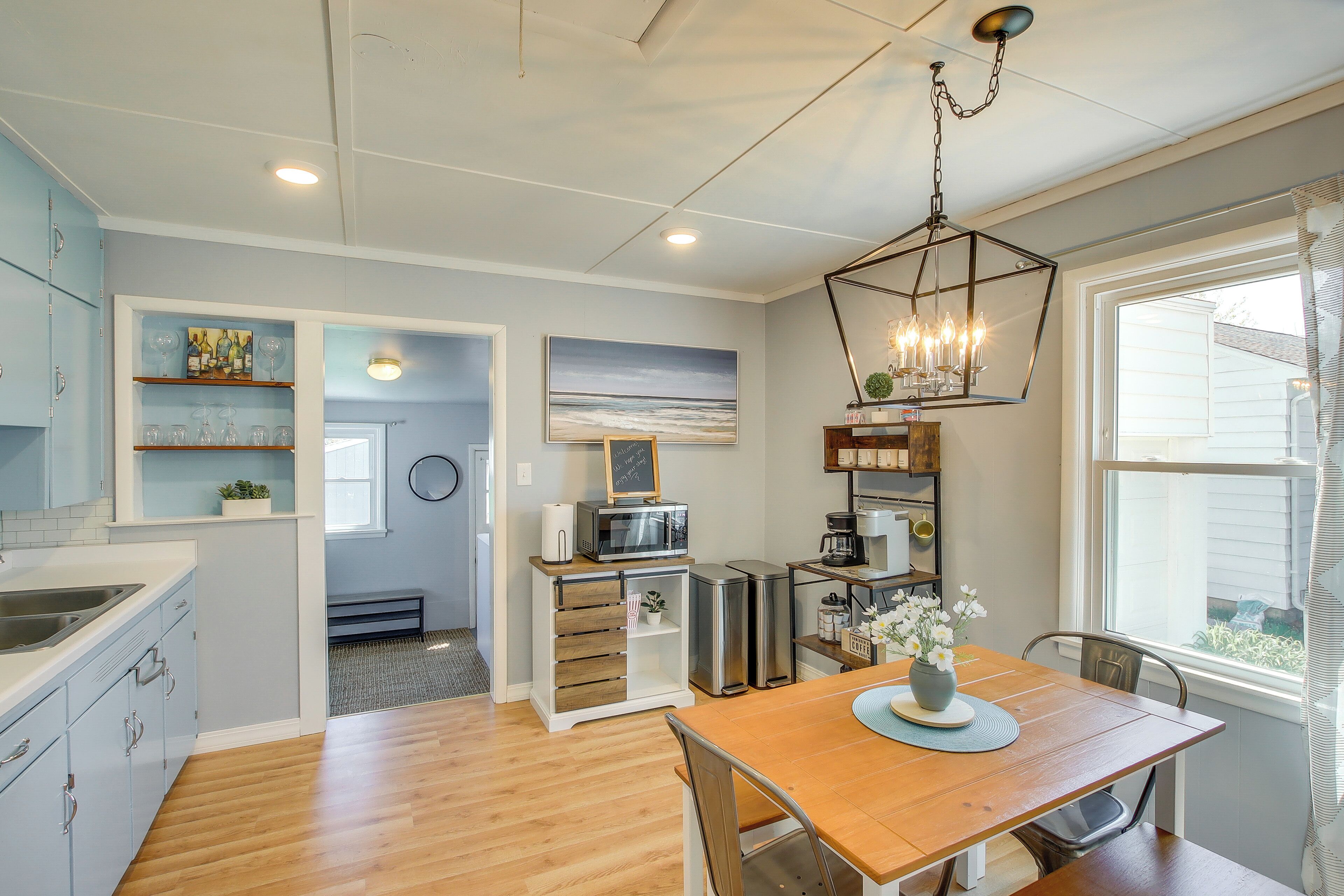 A modern kitchen with wooden cabinets, a dining table, and a view of the outdoors.