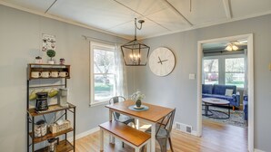 A dining area with a wooden table, bench, and a coffee station with a coffee maker and jars. - Sturgeon Bay Home ~ 6 Mi to Potawatomi State Park (Sturgeon Bay)