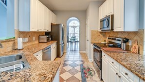 A modern kitchen with granite countertops, stainless steel appliances, and white cabinetry. - North Carolina Getaway on Pinehurst Golf Course! (Pinehurst)