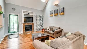 A living room with a fireplace, a TV, and two sofas. - North Carolina Getaway on Pinehurst Golf Course! (Pinehurst)