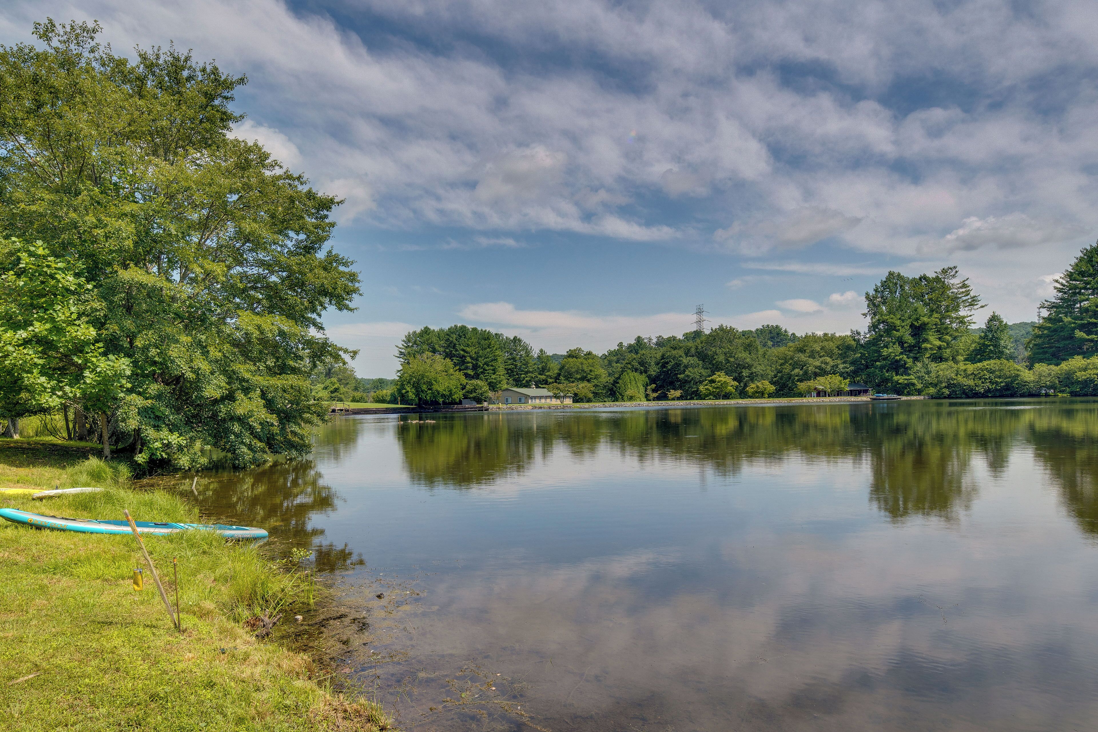 Ein ruhiger See mit einem Kanu am Ufer, umgeben von üppiger Vegetation und Bäumen.