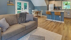 A modern kitchen with white cabinets, a refrigerator, and a window with a view of greenery. - Dog-friendly Mills River Retreat Near Hiking! (Mills River)