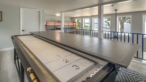 Une table de billard avec des zones numérotées, un lit superposé et un balcon avec vue.