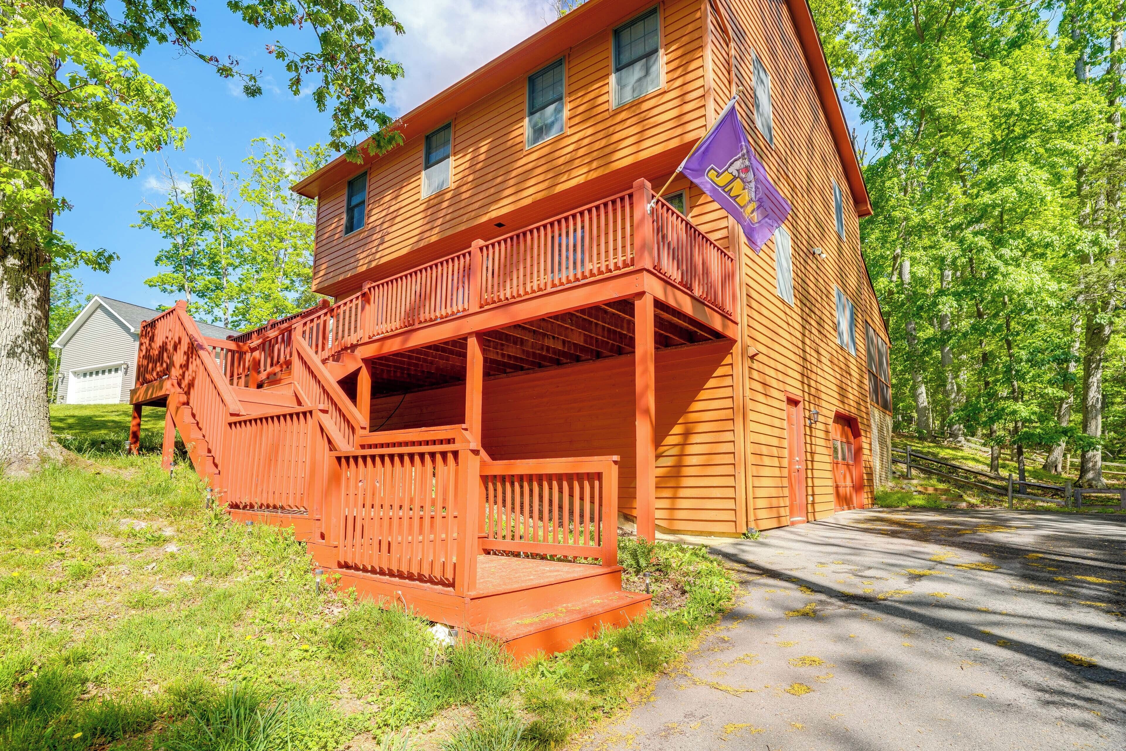 A two-story wooden building with a balcony, a flag, and a staircase leading to the entrance.