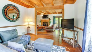 A living room with a wooden ceiling, a round mirror, a sofa, a coffee table, a TV on a stand, and a fireplace. - Mcgaheysville Home w/ Screened Porch & Gas Grill! (McGaheysville)