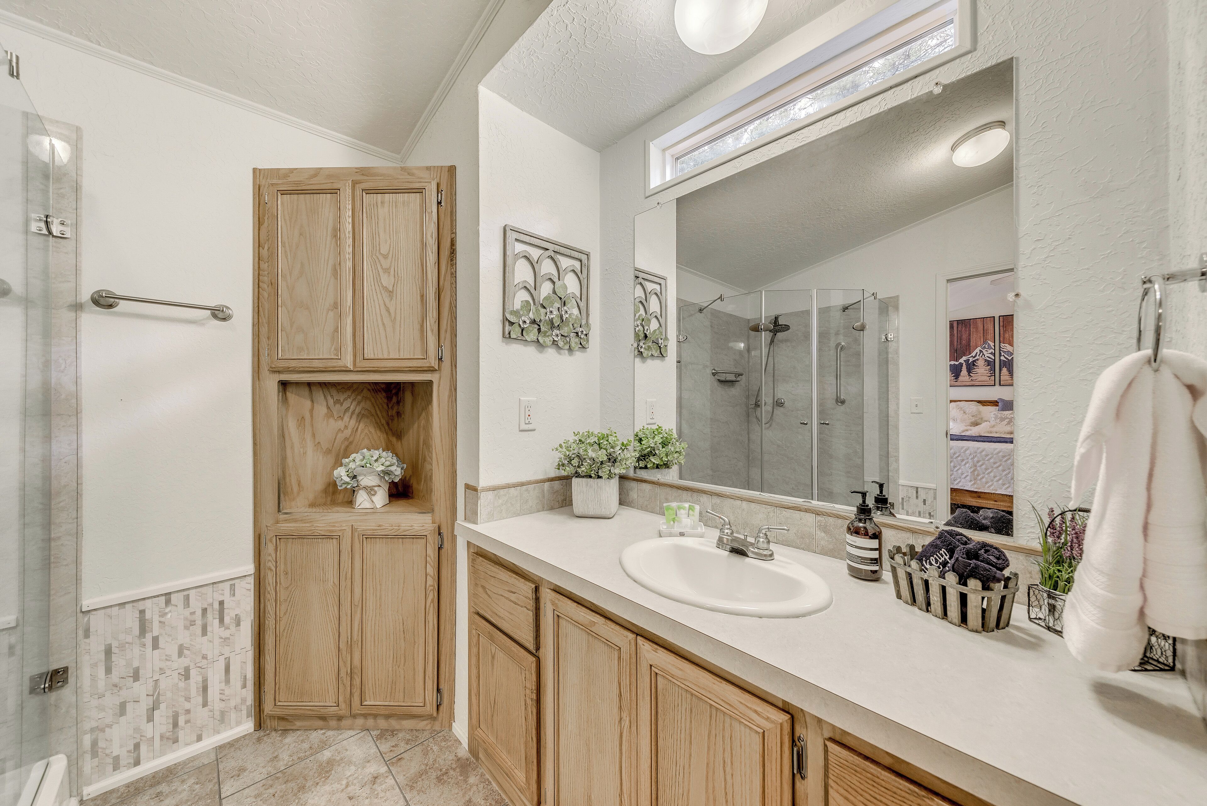 Une salle de bain moderne avec une douche, un lavabo et des meubles en bois.