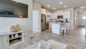 A modern kitchen with white cabinetry, a built-in microwave, and a stainless steel refrigerator. - Shuttle to Beach: Millville By the Sea Retreat (Millville)