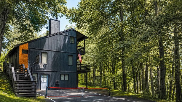 A modern house with a basketball court, surrounded by trees. - Pickleball Court & Hot Tub: 'wishbone Cabin' (Waynesville)